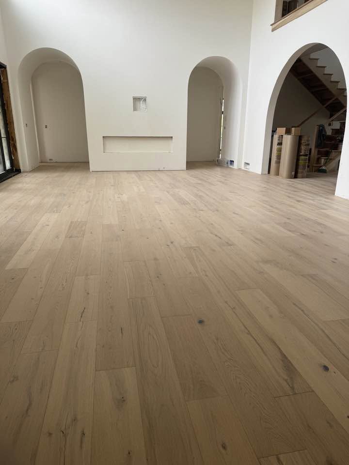 Hardwood flooring connecting rooms through curved openings