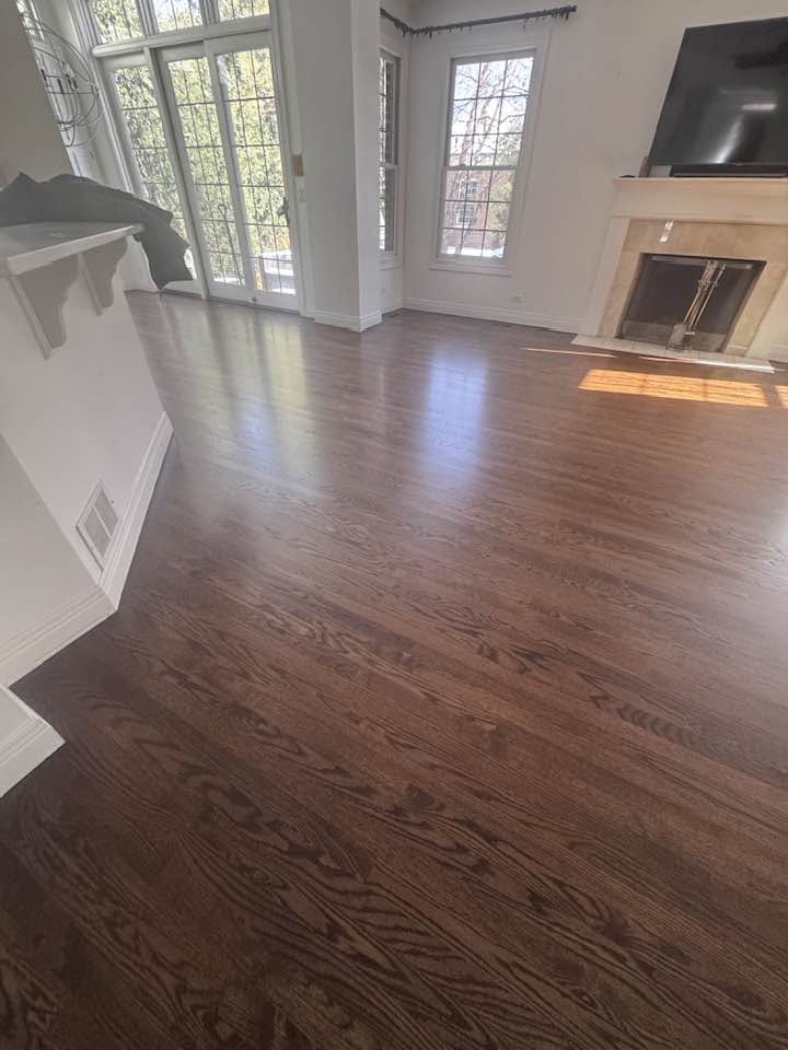Finished dark hardwood flooring surrounding white posts in an MGM project
