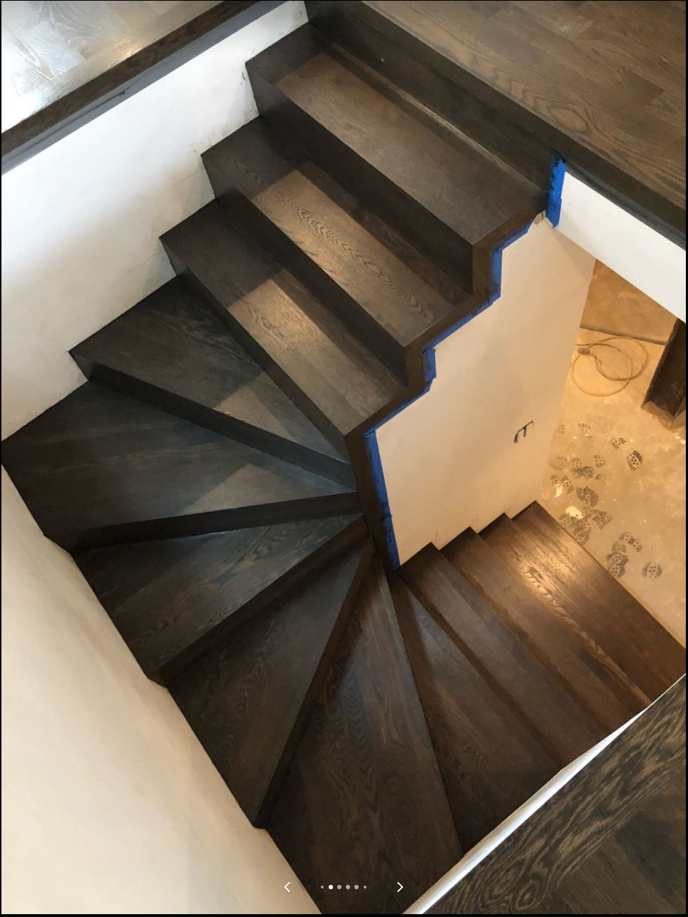 Curved staircase with dark refinished wood treads viewed from above
